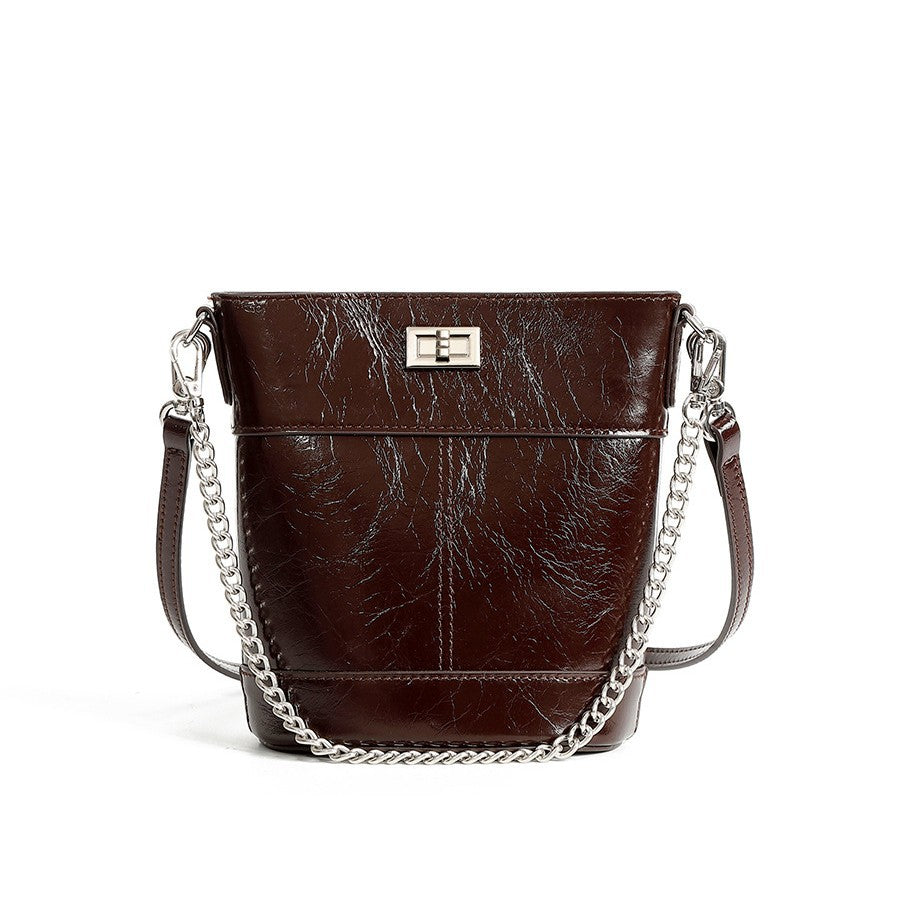 Brown leather handbag with chain detail on a white background