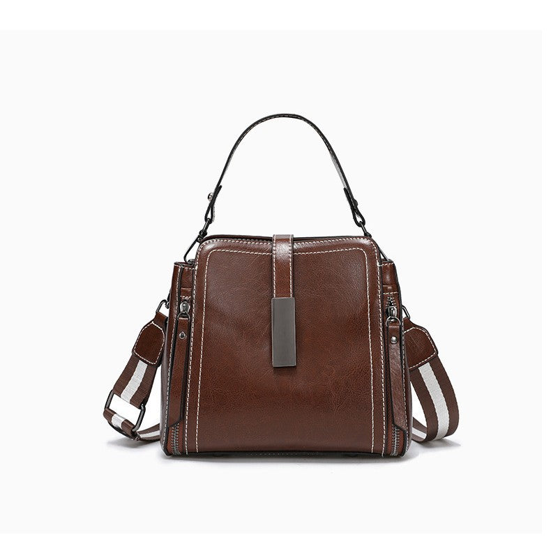 Brown leather handbag with multiple straps on a white background