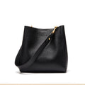 Black leather handbag with gold zipper on a white background
