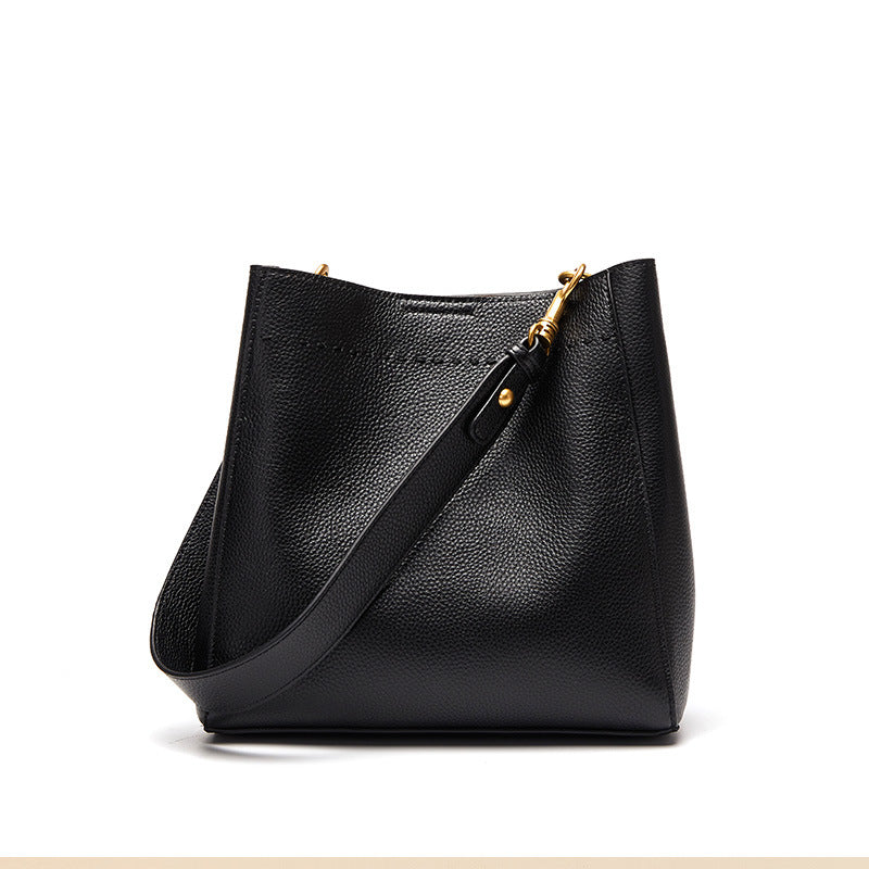 Black leather handbag with gold zipper on a white background