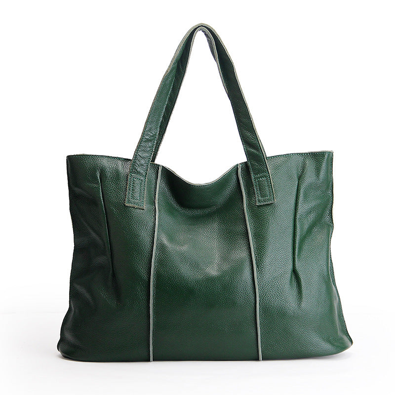 Green leather tote bag on a white background